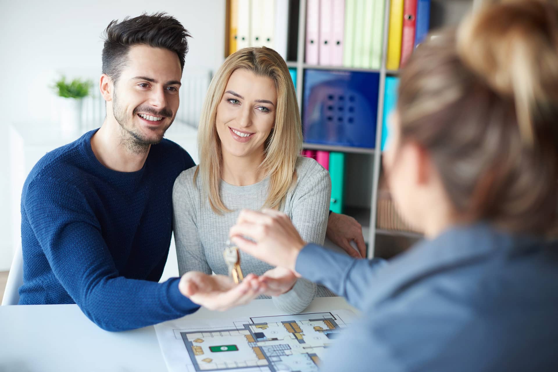 Estate agent giving keys to couple